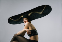 Portrait Of A Feminine Fashion Model Wearing Extravagant Hat With Horns