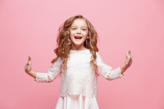 the beautiful little girl in dress standing and posing over white background