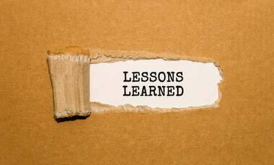 Aufkleber - The text LESSONS LEARNED appearing behind torn brown paper