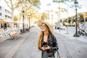 Wall Mural - Young woman tourist in hat walking on the famous pedestrian boulevard in Barcelona city