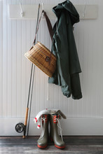 Raincoat, Basket And Fishing Pole Hanging On Hooks