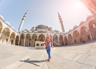 Wall Mural - Happy attractive muslim woman travel in Turkey, posing in courtyard of Suleymaniye mosque, religion and tourist concept.