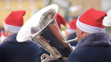 Festive Brass Band Musicians In New Year Hats Entertaining Passers-by In Street