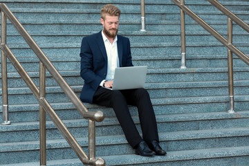 Wall Mural - Handsome young man with laptop, outdoors