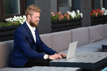 Wall Mural - Handsome young man with laptop, outdoors