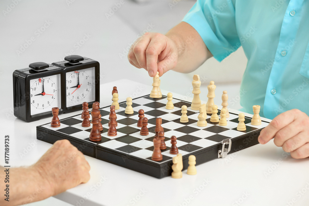 Elderly men playing chess at home