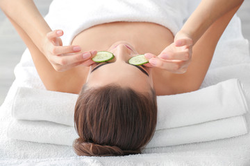 Canvas Print - Young woman with cucumber slices in spa salon