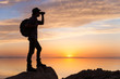 © odysseystock/Stocksy - Sunset Silhouette of Backpacker Searching With Binoculars