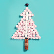 Fir tree silhouette from pink marshmallows on blue background