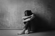 © Africa Studio - Battered young woman sitting near concrete wall