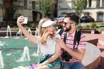 Wall Mural - Happy young tourists taking selfie outdoors