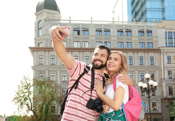 Wall Mural - Happy young tourists taking selfie outdoors