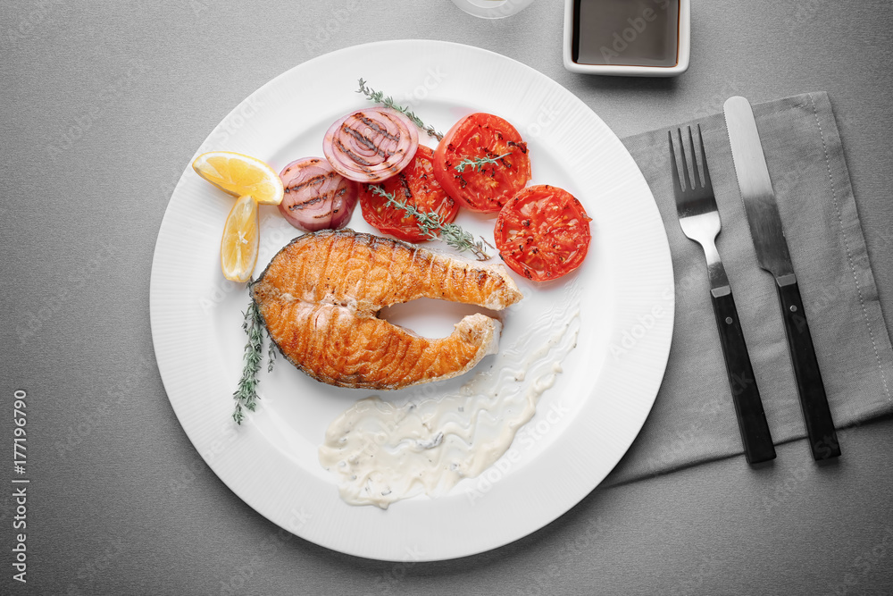 Grilled salmon steak with vegetables on plate