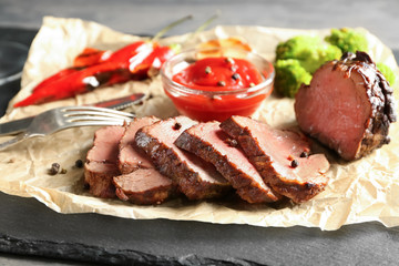 Wall Mural - Sliced tasty steak with sauce on slate plate