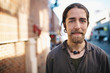 © Rob and Julia Campbell/Stocksy - Portrait of young traveler man standing on city sidewalk