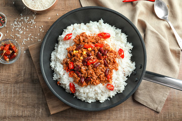 Poster - Frying pan with chili con carne and rice on table