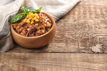 Wall Mural - Chili con carne in bowl on wooden table