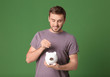 © Africa Studio - Young man with piggy bank on color background