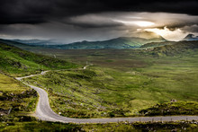 The Narrow Road That Leads To Ballaghisheen In Kerry, Ireland. In The Distance, The Rain Falls On The Hills And The Storm Approaches