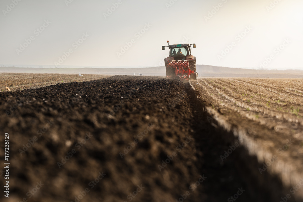Tractor plowing fields  -preparing land for sowings - obrazy, fototapety, plakaty 