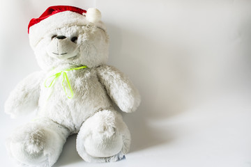 toy teddy bear wearing santa hat, on a light background.