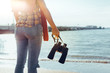 © tinyakov - Young Woman With Binoculars In Hand Standing By The Sea And Enjoying View Of Nature, Rear View