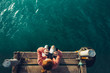© tinyakov - Young Girl Sits On The Pier And Looks At Sea Through Binoculars, Top View. Adventure Vacation Discovery Travel Concept