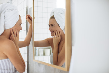 Wall Mural - Woman Looking Herself in Bathroom Mirror