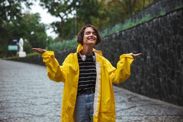 Wall Mural - Portrait of a happy teenage girl wearing raincoat