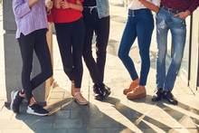 Legs Of Group Of Casual Young People. Youth Fashion. Crop Of Diverse Informal Students Standing In Row Outdoors Urban Background