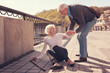 Polite elderly man helping a woman to get up