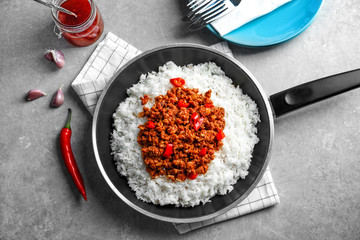 Poster - Frying pan with chili con carne and rice on table