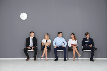 Poster - Group of people waiting for job interview on gray wall background