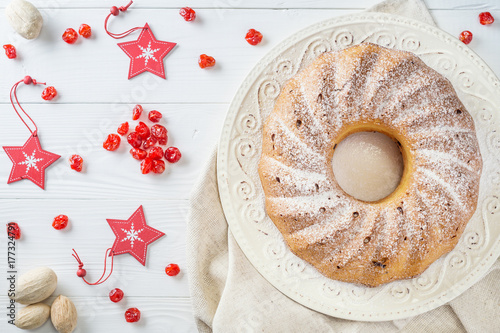 Fotomural Traditional Christmas bundt cake with raisins, dried cherries, cranberry and sugar powder on a white plate