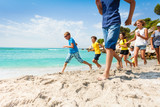 Fototapeta  - Group of happy kids running on white sand beach