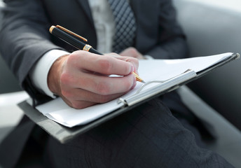 Businessman signs a contract. Holding pen in hand.