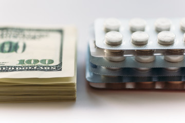 Wall Mural - Bundle of money and  pack of medication tablets or drug pills, close-up. Expensive health care concept