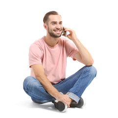 Wall Mural - Attractive young man with smartphone on white background