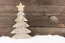 Shabby Chic Wooden Christmas Tree With Twine Garland Standing In Snow Against A Rustic Wood Background