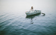© HOWL/Stocksy - Lonely girl floats alone in a row boat on a foggy New England morning.