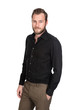 © _robbie_ - Handsome man wearing a black shirt and brown pants, hand in pocket standing against a white background looking at camera.