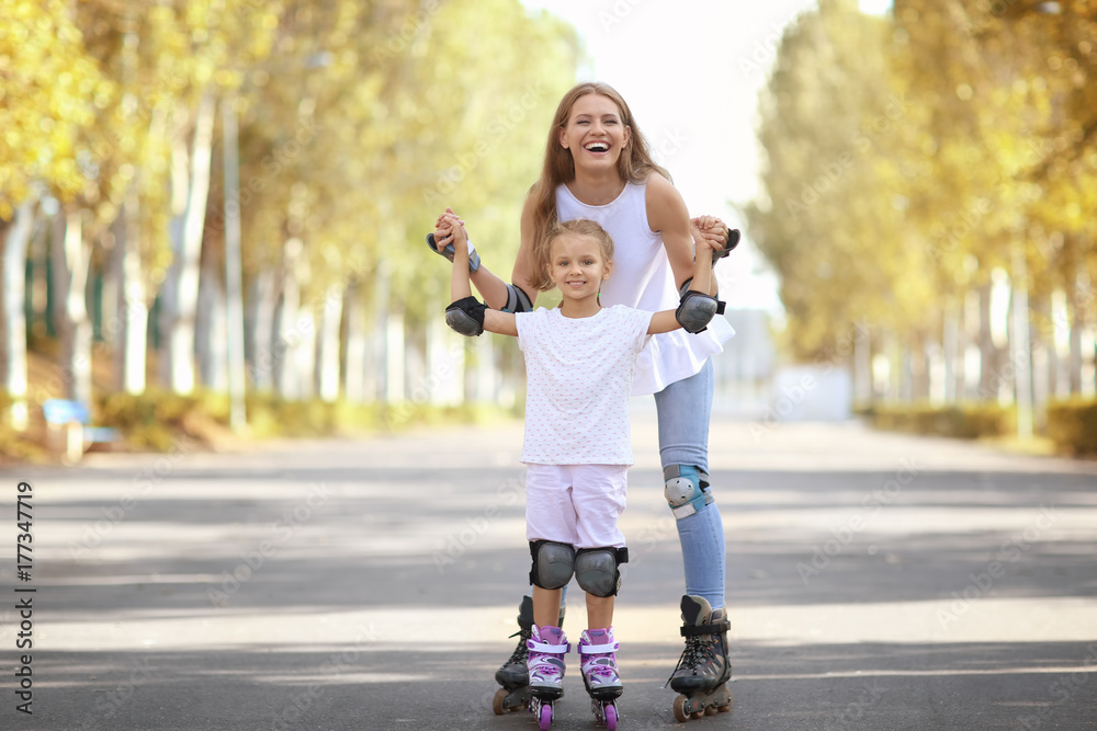 Mother with daughter rollerskating in park