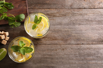 Canvas Print - Glasses of cocktail with lemon and mint on wooden background