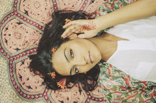 Beautiful Indian Woman Laying On Patterned Blanket