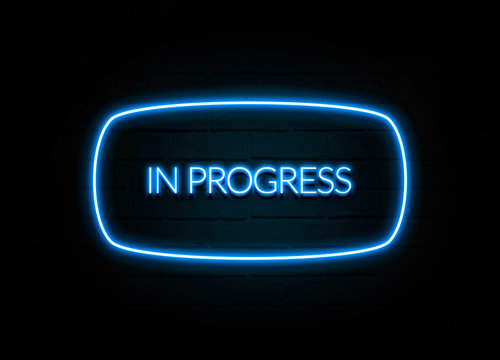 In Progress  - colorful Neon Sign on brickwall
