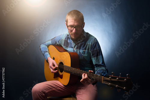 Plakat Przystojny młody muzyk gra na gitarze