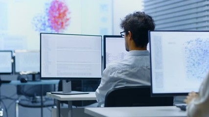 Fototapete - Multi-Ethnic Team of International Computer Scientists Develop Neural Network at Their Workstation. Office is Full of Displays with Functioning AI and Neural Data Infographics.