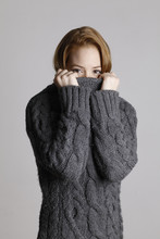 Girl With Red Hair Hiding Behind Collar Of Sweater