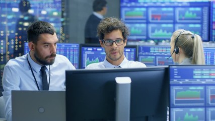 Aufkleber - Professional Broker Consults Stock Exchange Trader at His Workstation. Multi-Ethnic Team at Stock Exchange Office is Busy Selling and Buying Stocks on the Market. Displays Show Relevant Data Numbers.