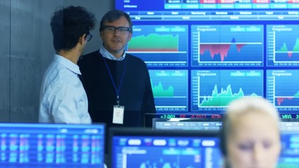 Poster - Stock Trader Enters Office and Shakes Hands with a Colleague, Makes Work Related Chat with Other. Busy Office with Multi-Ethnic Team of Brokers, Dealers. Displays Show Numbers and Infographics.